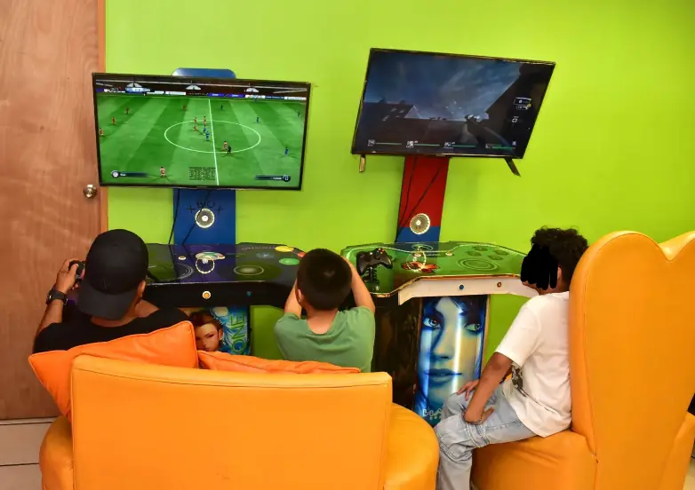 Niños jugando videojuegos en pantalla grande